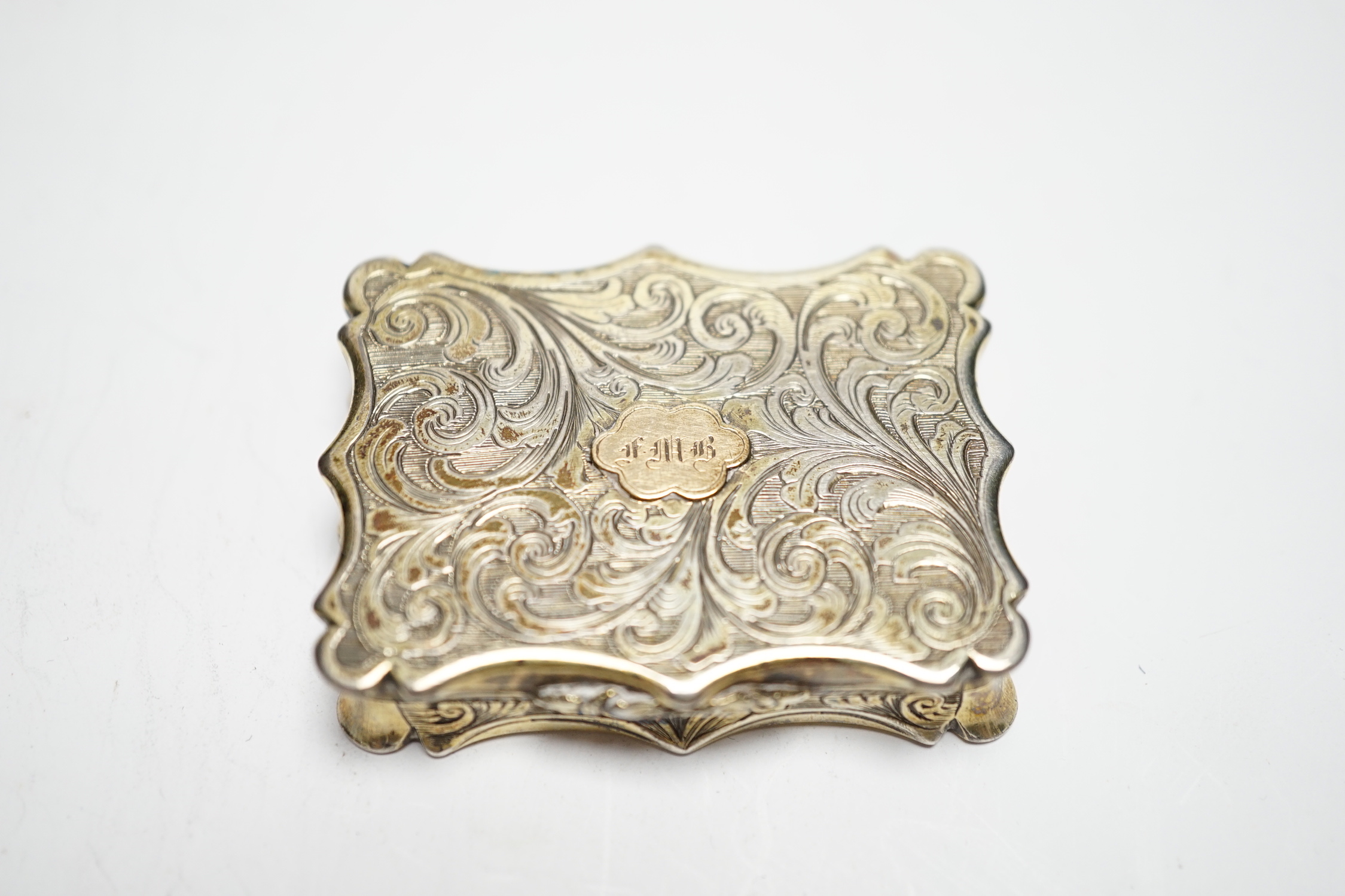 An early Victorian engraved silver gilt vinaigrette, by Nathaniel Mills, Birmingham, 1842, 46mm, with engraved initials.